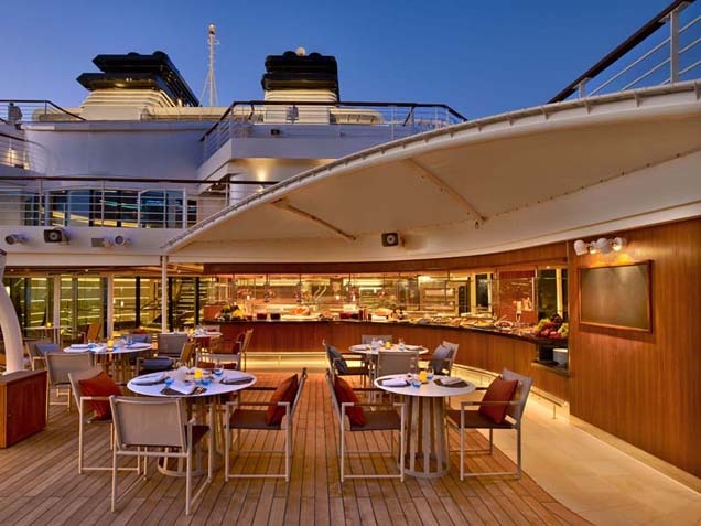 Happy couple seated at Patio bar on deck of Seabourn Odyssey