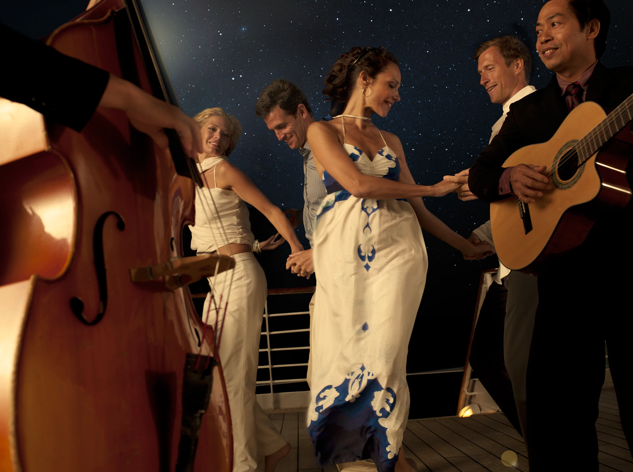 Dancing under the stars on deck, couples are laughing.